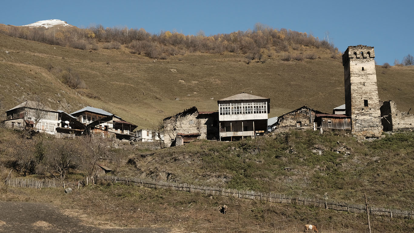 Der Blick auf ein Bergdorf in Oberswanetien zeigt die für diese Siedlungen typische Struktur: einen Wehrturm und einzelne Machubis als Beispiele mittelalterlicher Architektur, und die Erweiterungen alter Gebäude durch Balkonvorbauten aus der Sowjetzeit.